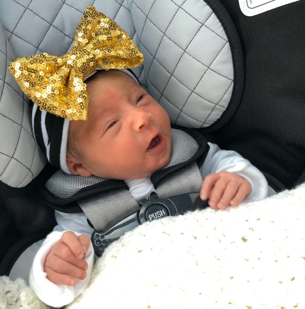 Kennedy Beck, a newborn baby, rests in a car seat as she goes home for the first time